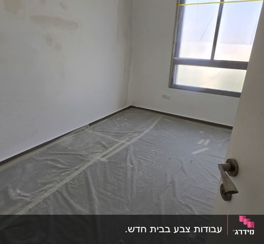 חדר עם קירות צבועים ויריעות מגן על הרצפה